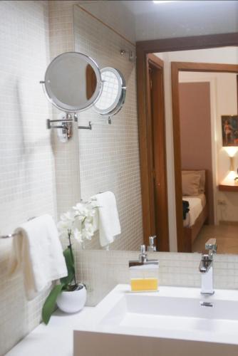 a bathroom with a sink and a mirror at Sole Apartment in Palermo