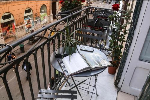 a table with a potted plant on top of a balcony at Sole Apartment in Palermo