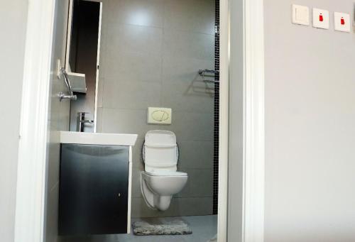 a bathroom with a white toilet and a sink at Mus homes in Accra