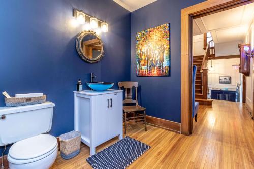 a bathroom with a toilet and a blue wall at The Butler House Bed & Breakfast in Niagara Falls