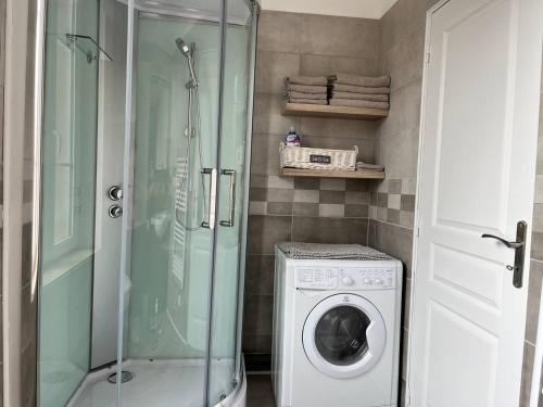 a bathroom with a shower and a washing machine at Superbe appartement proche port Guillaume in Dives-sur-Mer