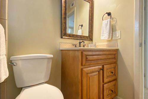 La salle de bains est pourvue de toilettes, d'un lavabo et d'un miroir. dans l'établissement Sugar Sands B, à St. Pete Beach