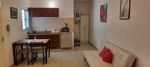 a living room with a couch and a table and a kitchen at TU REFUGIO - Alquiler Temporario in Santiago del Estero