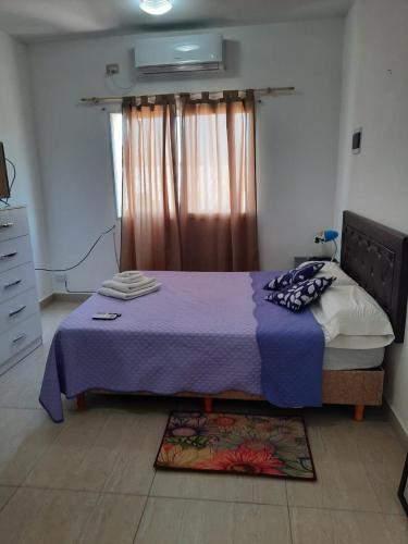 a bedroom with a purple bed with a window at TU REFUGIO - Alquiler Temporario in Santiago del Estero