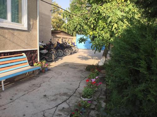 a row of motorcycles parked next to a building with a bench at RAHAT Guest House & Hostel in Toktogul in Toktogul