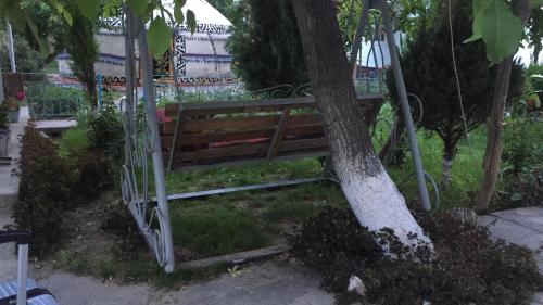 a wooden bench sitting next to a tree at RAHAT Guest House & Hostel in Toktogul in Toktogul
