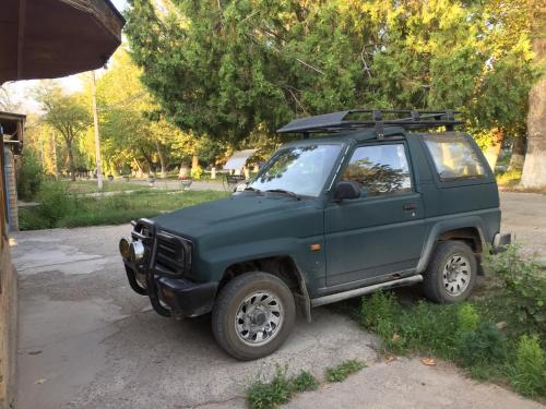 a green jeep parked in a parking lot at RAHAT Guest House & Hostel in Toktogul in Toktogul