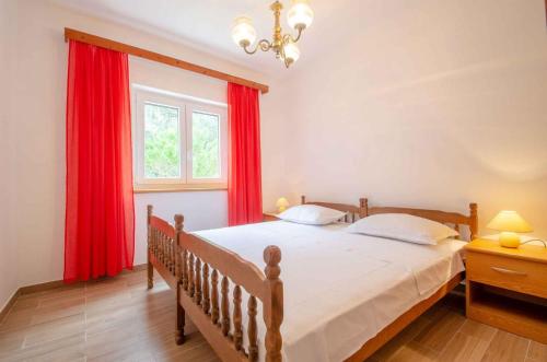 a bedroom with a bed with red curtains and a window at Holiday home in Blato Insel Korcula 6411 in Prigradica