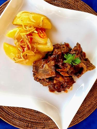 a plate of food with meat and cabbage on a table at Cersen Resort Lombok in Kuta Lombok