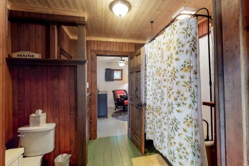 a bathroom with a shower curtain with a toilet at Highland Playhouse in Windham