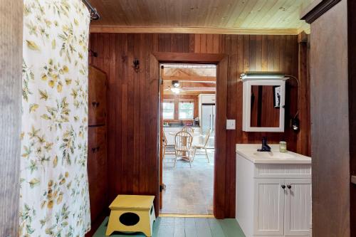 a bathroom with a sink and a door to a kitchen at Highland Playhouse in Windham