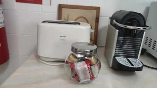 a glass jar on a counter next to a toaster at House of Roses in Ponta Delgada