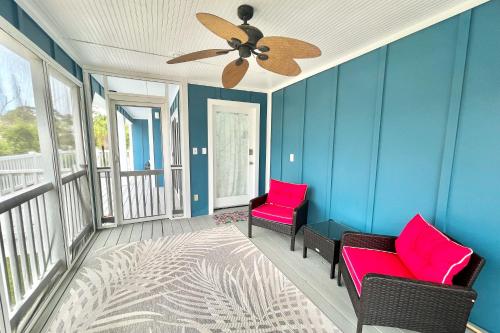 a porch with two chairs and a ceiling fan at Shore Bird in Port Saint Joe