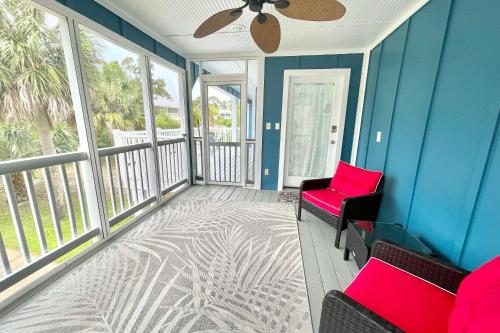 a balcony with two chairs and a ceiling fan at Shore Bird in Port Saint Joe