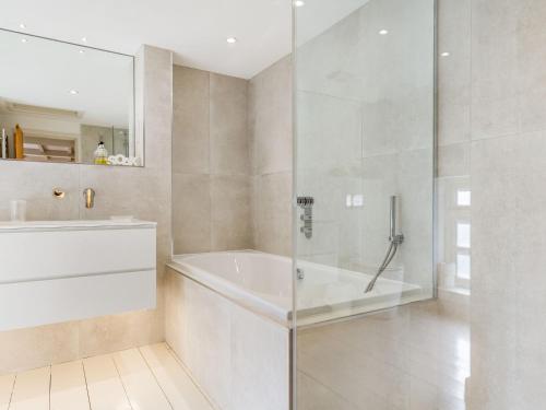 een witte badkamer met een bad en een douche bij 3 Rose Cottages in St. Agnes 