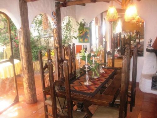 Hostal Madre Tierra في كوسكو: غرفة طعام مع طاولة خشبية عليها نباتات
