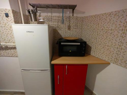 a small kitchen with a microwave and a refrigerator at Grozavesti Apartment near University in Bucharest
