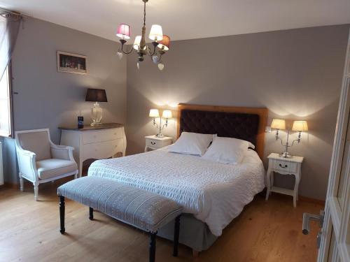 - une chambre avec un lit, une chaise et deux tables dans l'établissement Maison confortable avec balcon au cœur de Cadouin, proche de Dordogne et grands sites touristiques - FR-1-616-196, au Buisson de Cadouin