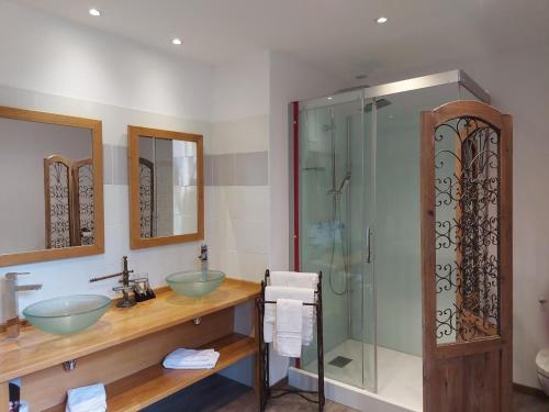 une salle de bain avec deux lavabos et une douche en verre dans l'établissement Maison confortable avec balcon au cœur de Cadouin, proche de Dordogne et grands sites touristiques - FR-1-616-196, au Buisson de Cadouin