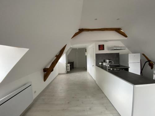 une cuisine aux murs blancs et un long couloir dans l'établissement Appartement confortable proche des Thermes avec lave-vaisselle et options de location de linge - FR-1-541-9, à La Roche-Posay