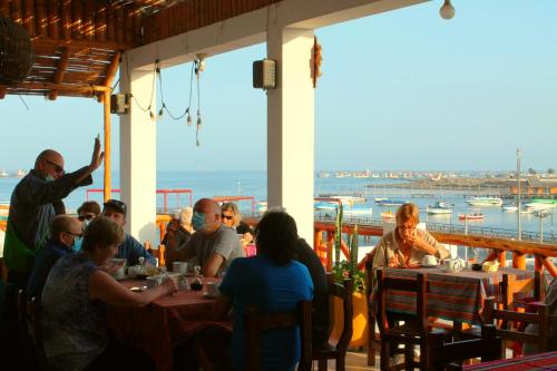 a group of people sitting at tables in a restaurant at El Gamonal - Paracas in Paracas