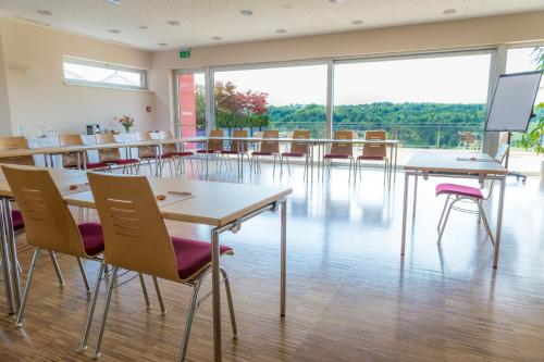 a classroom with tables and chairs and a large window at Das Eisenberg in Sankt Martin an der Raab