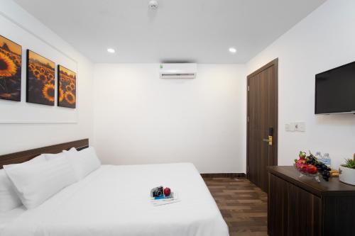 a bedroom with a bed and a flat screen tv at AOA Danang Beach Hotel in Da Nang