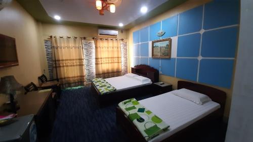 芹苴的住宿－譚泰多酒店，一间设有两张床和蓝色墙壁的客房