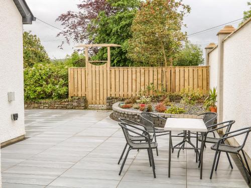 a patio with a table and chairs and a fence at Wee Andy's in Buncrana