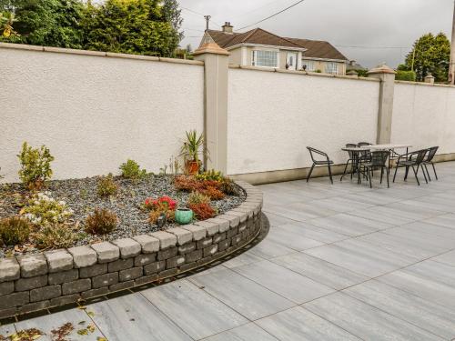 a patio with a table and chairs and plants at Wee Andy's in Buncrana