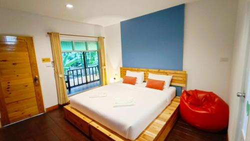 a bedroom with a large bed and a window at Nua Tone Resort Bang Tao & Cafe in Bang Tao Beach