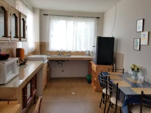 uma cozinha com um lavatório e uma mesa com cadeiras em HERMOSO Y COMODO Departamento vacacional, vista única! TOTALMENTE AMOBLADO E INDEPENDIENTE em Ambato