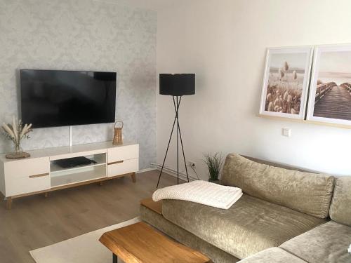 a living room with a couch and a flat screen tv at stylisches Ferienhäuschen in Güstrow