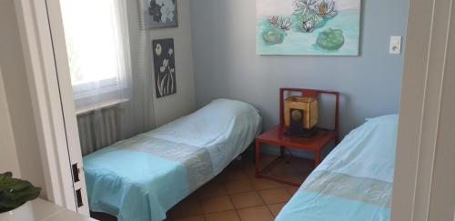 une chambre avec deux lits, une table et une fenêtre dans l'établissement Sur le quai de port fréjus, à Fréjus