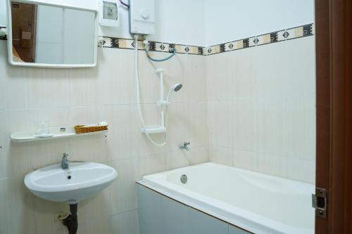 a white bathroom with a sink and a bath tub at Hung Phu Home & Apartment in Cái Răng
