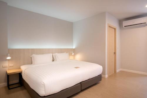 a bedroom with a large white bed in a room at The Pride Hotel Phitsanulok in Phitsanulok