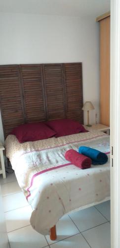 a bedroom with a large bed with red and blue pillows at hippocampe f2 in Fréjus