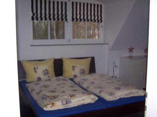 a bedroom with two beds and a window at Weißes Traumhaus in Glowe