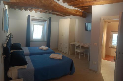 a blue bedroom with two beds and a table at La casa di Samarcanda in Uliveto Terme