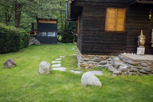 a yard with rocks and a house at Cabana La Cuib Sovata in Sovata