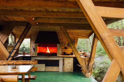 an outdoor kitchen with a fireplace in a log cabin at Cabana La Cuib Sovata in Sovata