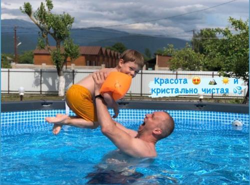 un hombre y un niño en una piscina en MiMi, en Tsandrypsh