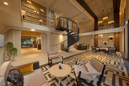 a large living room with a staircase and a table at Maladee Rendezvous Hotel Chiang Mai in Chiang Mai