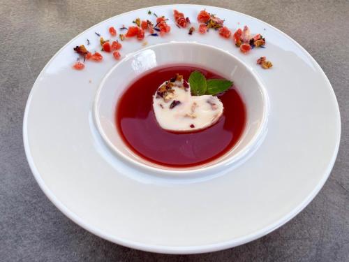 a white plate with a bowl of sauce and a dessert at Chicago Vendégház in Szentes