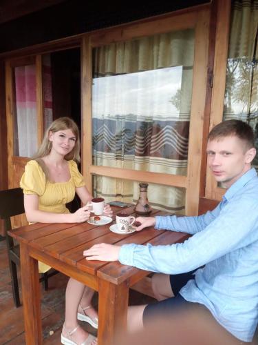 a man and a woman sitting at a wooden table at Barn Hills in Ella