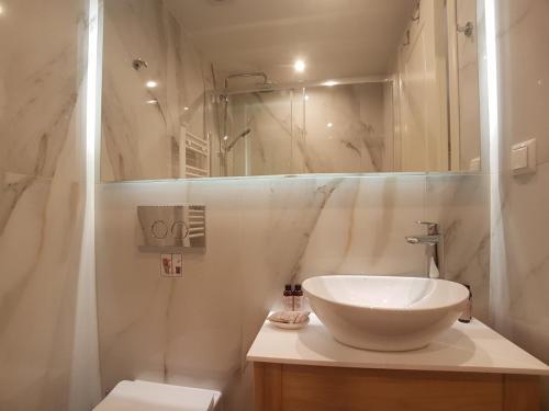 a bathroom with a white sink and a shower at Sole e Luna Studio · Corfu Old Town in Corfu