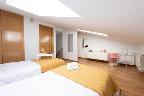 a hotel room with two beds and a room with at Apartamento La Merced. in Guadalajara