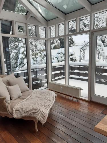 a living room with a couch and some windows at Chalet Madeleine - 160 qm Ferienhaus in Baden-Baden