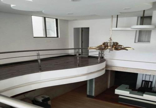 a living room with a staircase and a chandelier at Silver Suite in Chikmagalūr