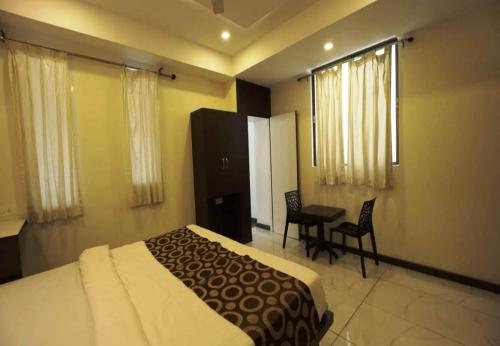 a hotel room with a bed and a table and chairs at Silver Suite in Chikmagalūr